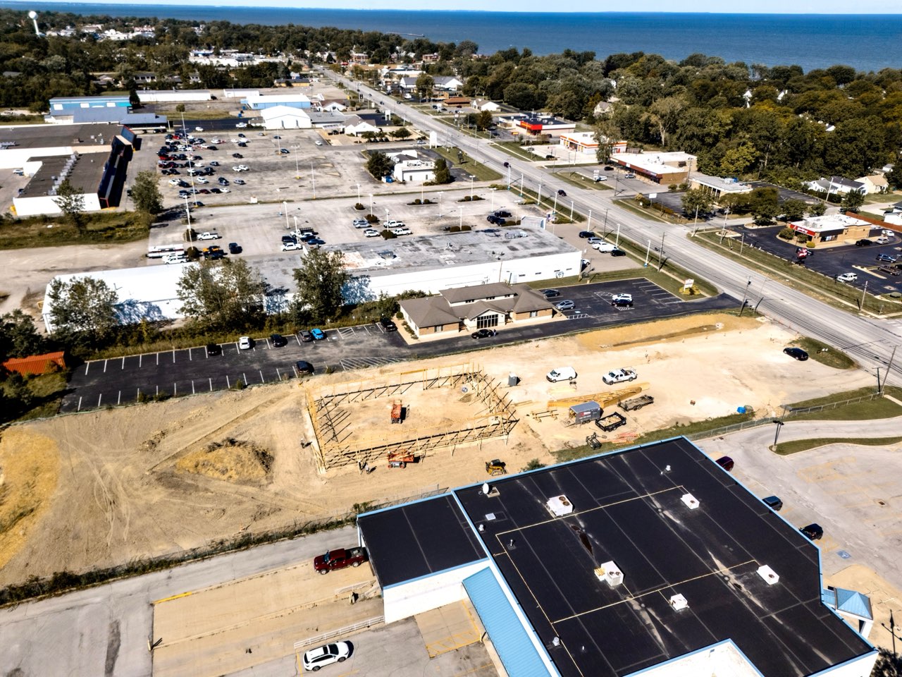 Wide aerial view of the Apex Strength Club construction site on Liberty Avenue with Lake Erie in the background